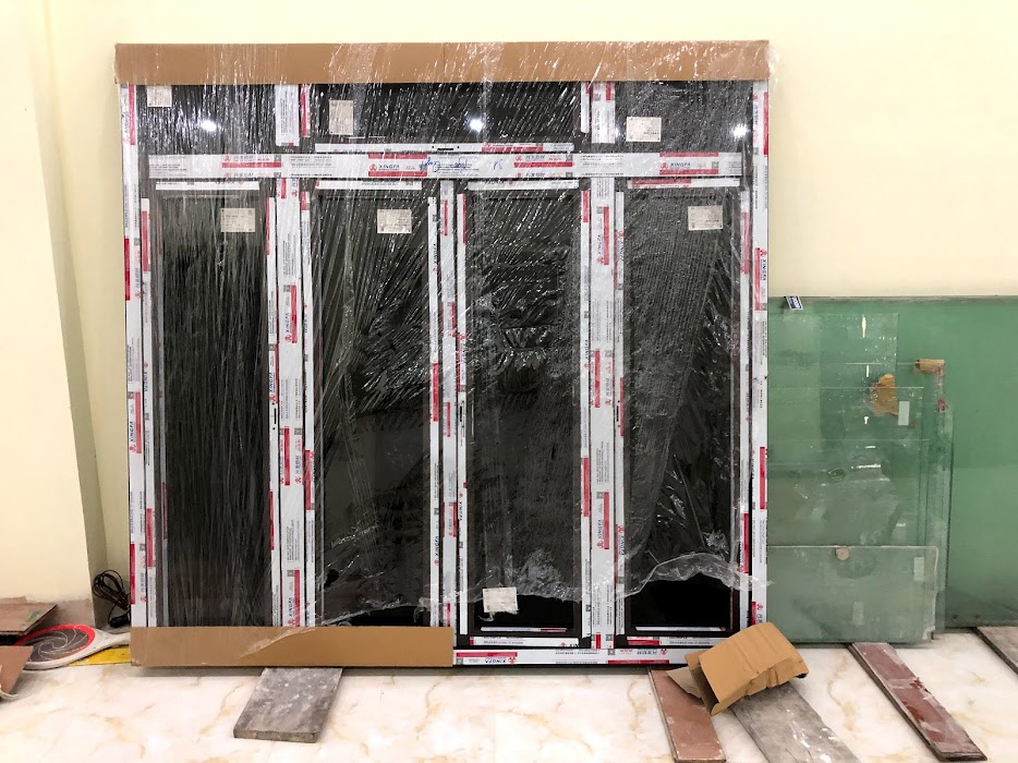Cửa nhôm kính Xingfa bốn cánh mới lắp đặt còn bọc nilon trong nhà